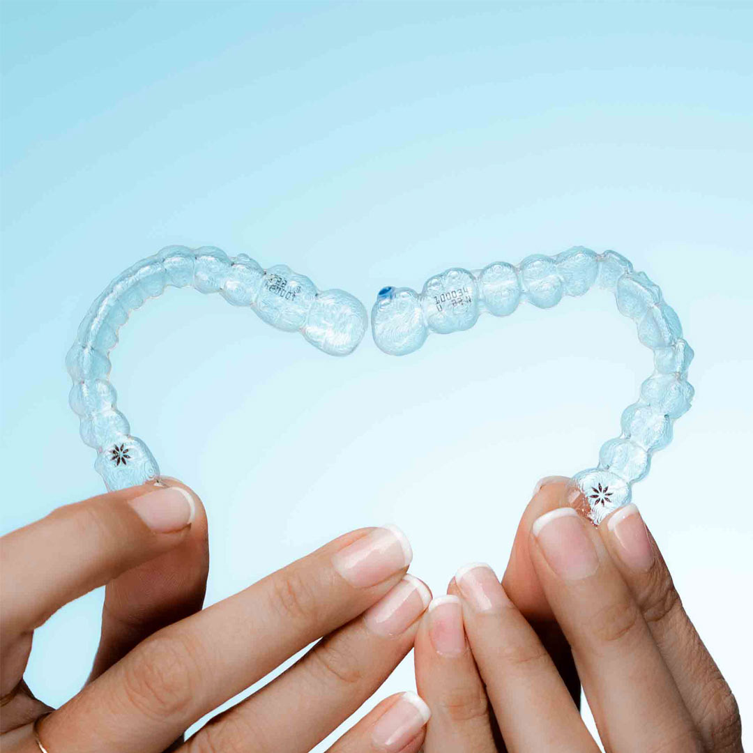alineadores invisalign en manos de mujer